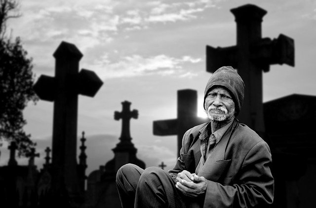 hombre sentado en un cementerio